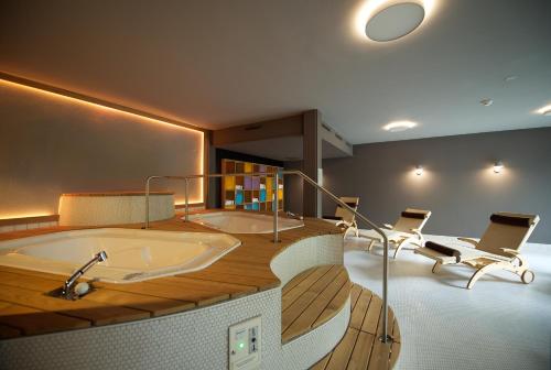 因特拉肯Hotel Artos Interlaken的带浴缸和两把椅子的大浴室