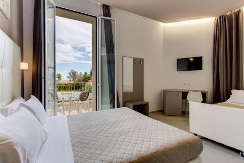 里米尼奥古斯特亚别墅酒店的酒店客房设有一张床和一个阳台。