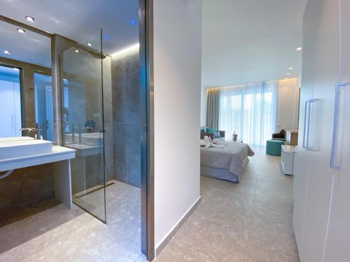 拉多斯Lardos Bay Hotel的带淋浴、床和盥洗盆的浴室