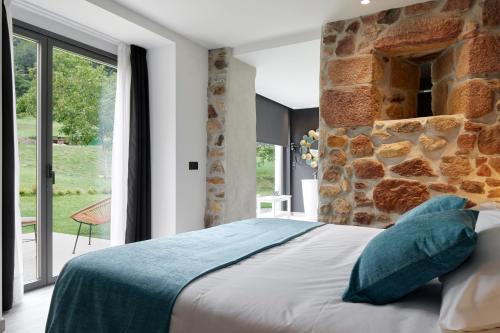 AiaOribar Casa Rural的一间卧室设有一张床和石墙