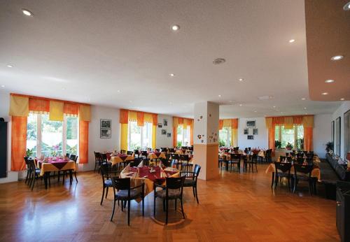 舍内克Hotel Haus am Ahorn的大楼内带桌椅的用餐室
