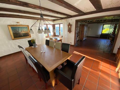 费尔德伯格Schwarzwald-Villa mit Indoor-Pool的一间带木桌和椅子的用餐室