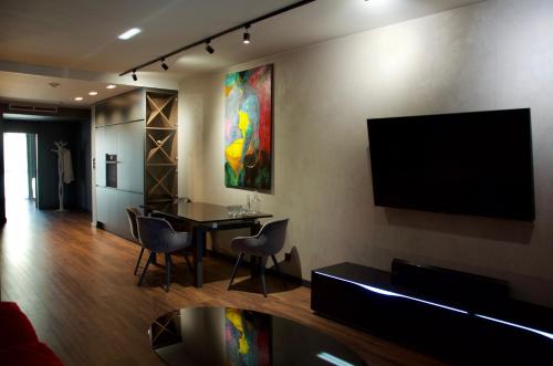 拉多姆Aparts Hotel Radom的客厅配有桌子和墙上的电视