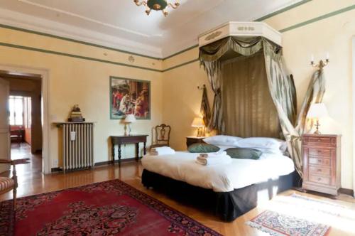威尼斯Charming large palazzo in center Venice for up to 9 people的一间卧室配有天蓬床和红色地毯。
