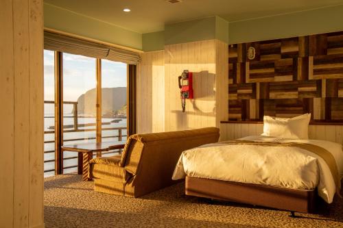 伊豆明治馆碧风日式旅馆的卧室配有床、椅子和窗户。