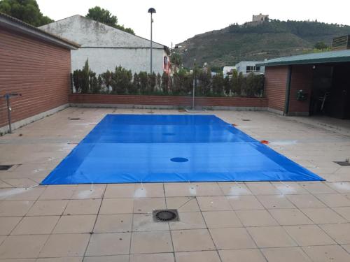 梅基嫩萨TU CASA EN MEQUINENZA CON WIFI的庭院里的一个大型蓝色游泳池
