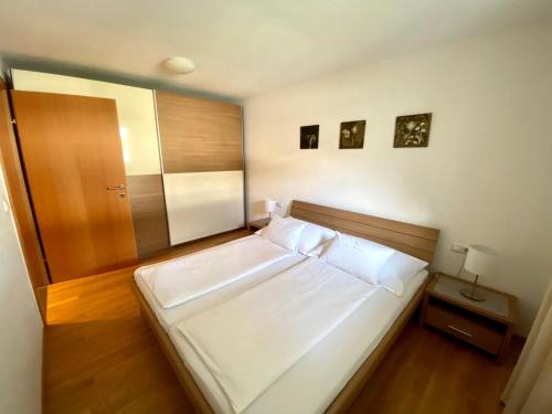 多恩比恩克里斯汀公寓的卧室配有一张白色大床,铺有木地板