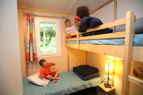Béhen乐巴尔德特里露营酒店的坐在双层床的枕头上的孩子