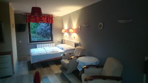 塔干尼采Miodowy Raj的客房设有两张床、椅子和窗户。
