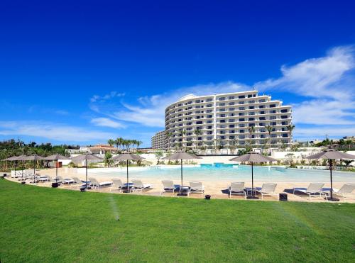 恩纳冲绳蒙特利水疗度假酒店的一个带椅子和遮阳伞的酒店和一个游泳池