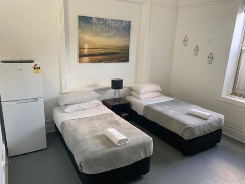 悉尼桑迪波特姆旅馆的客房设有两张床和一台冰箱。