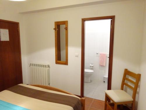 佩纳科瓦Hospedaria Lampião的一间卧室配有一张床,浴室设有卫生间