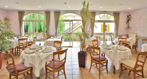 武耶罗迪斯切瓦尔布兰科克洛维斯酒店的餐厅设有白色的桌椅和窗户。