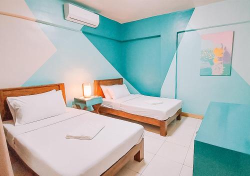 大雅台The NEST, Tagaytay的一间卧室设有两张床和蓝色的墙壁