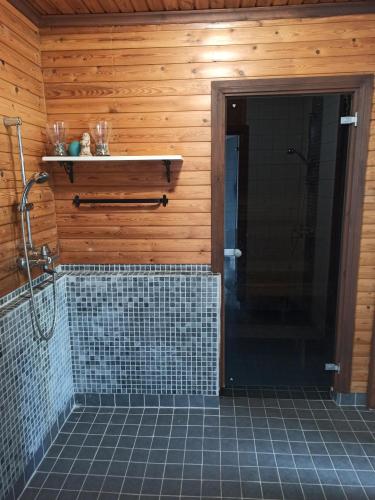 伊萨尔米Laukkumäki farm的一间带步入式淋浴间的浴室,铺有瓷砖地板。