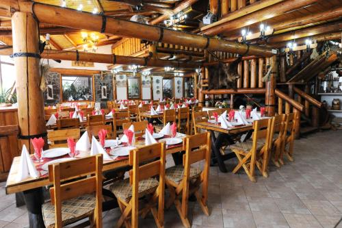 布什泰尼古拉迪汉姆宾馆的餐厅设有木桌和椅子,配有餐巾纸