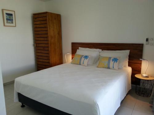 帕佩托艾SNP- PALMS的卧室配有一张带白色床单和枕头的大床。