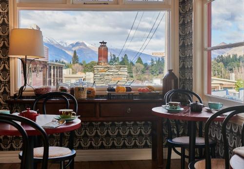 皇后镇The Dairy Private Hotel by Naumi Hotels的客房设有两张桌子和一个享有美景的窗户。