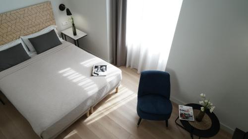 瓦伦西亚里尔波特尔MD设计酒店 的一间卧室配有一张床和一张蓝色椅子