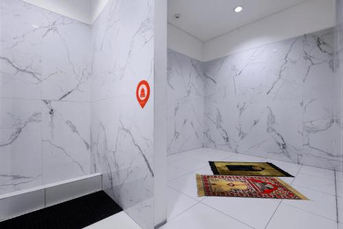 当格浪Starlet Hotel Jakarta Airport的浴室拥有白色的大理石墙壁和墙上的标志