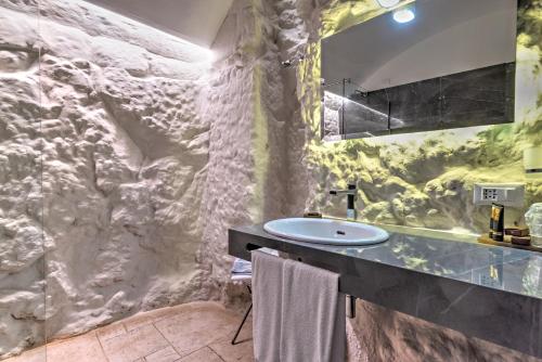 奥斯图尼诺维切托公园度假酒店的一间带水槽和石墙的浴室