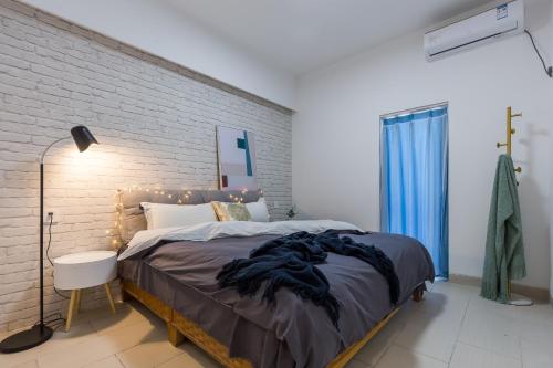 三亚三亚阳光海景公寓的一间卧室设有一张大床和砖墙