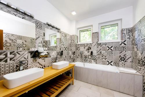 特伦钦Hotel Veverica的浴室配有2个盥洗盆和1个浴缸。