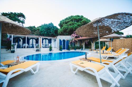 王子岛群Büyükada Loc'ada的一个带躺椅和遮阳伞的游泳池和一个游泳池
