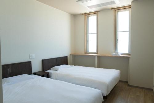 泉南市SORA RINKU的带2扇窗户的客房内的2张床