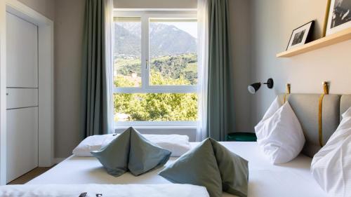 梅拉诺梅拉诺城市酒店的一间卧室设有一张大床和大窗户
