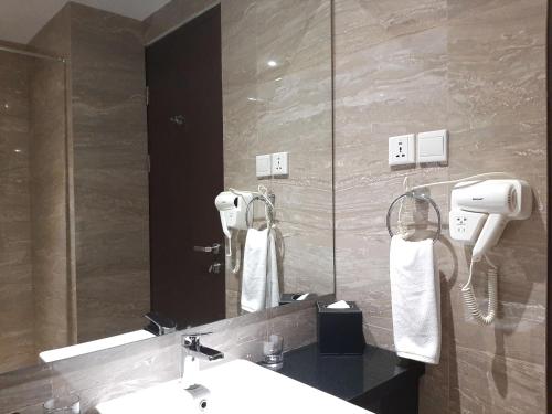 哥伦打洛省ASTON Gorontalo Hotel & Villas的一间带水槽和镜子的浴室
