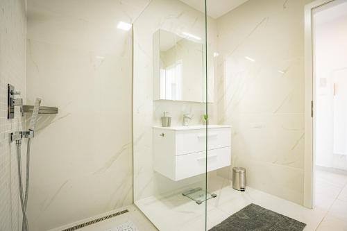 蒂萨菲赖德Panoráma Apartman Tiszafüred的白色的浴室设有玻璃淋浴间和水槽