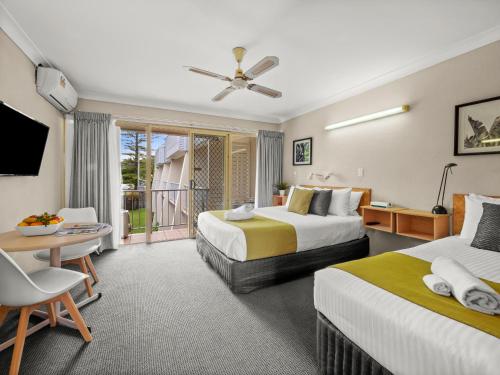扬巴扬巴太阳汽车旅馆的酒店客房设有两张床和一个阳台。