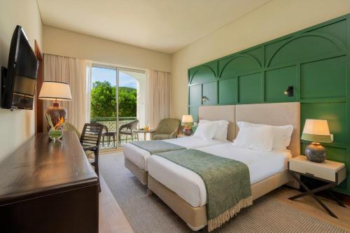 英雄港特塞拉岛马尔酒店的一间卧室配有一张大床和绿色床头板
