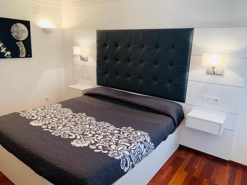 卡达克斯Cala Tere 2on pis的一间卧室配有一张大床和黑色床头板