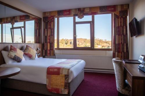 查珀尔利佐德韦斯特县酒店的酒店客房设有一张床、一张书桌和两个窗户。
