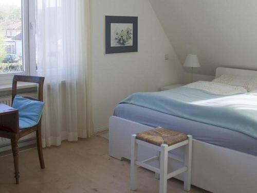 乌尔丁根-米赫尔霍芬Ferienhaus und Gästezimmer Cleo的卧室配有床、椅子和窗户。
