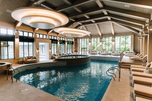 麦克尔斯菲尔德莫特拉姆霍尔酒店的酒店大堂的游泳池,设有椅子和游泳池