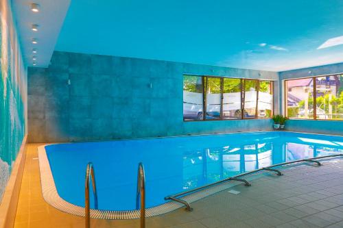 加茨比亚格拉Ośrodek wypoczynkowy Balt-Tur Feel Well Resort的一座拥有蓝色天花板的大型游泳池