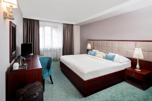 鲁容贝罗克库尔图拉酒店的酒店客房配有一张床、一张书桌和一台电视。