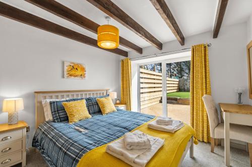 卡弗拉克Arrowan Common Farm Cottages的一间卧室配有一张床、一张书桌和一个窗户。