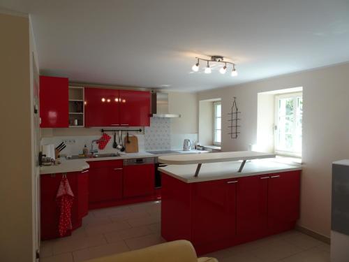 德累斯顿Das Gäste Haus的厨房配有红色橱柜和白色台面