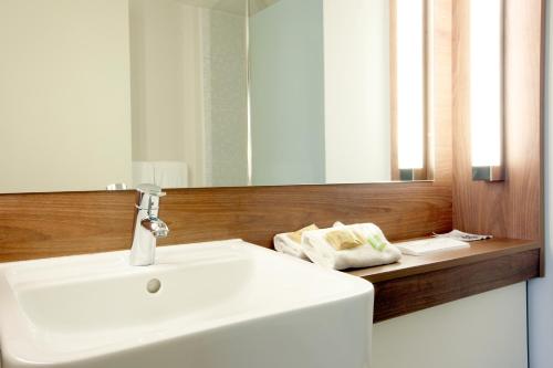 圣洛朗-德米尔里昂东圣艾修伯里机场钟楼酒店的浴室设有白色水槽和镜子