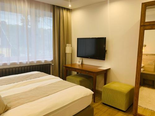 埃格尔Egria Apartments的配有一张床和一台平面电视的酒店客房