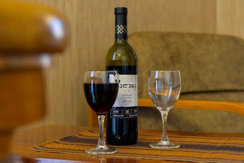 库塔伊西Gold Guest House的一张桌子上放着一瓶葡萄酒,放上两杯