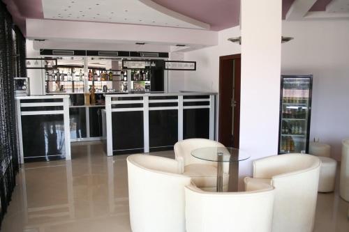 卡瓦尔纳阿克诺酒店的酒吧配有白色椅子和玻璃桌