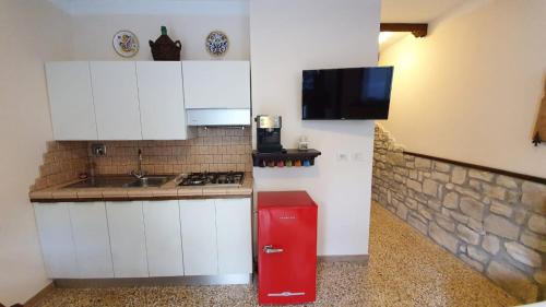 安杰利圣母Appartamento La Cupola的厨房配有白色橱柜和红色冰箱