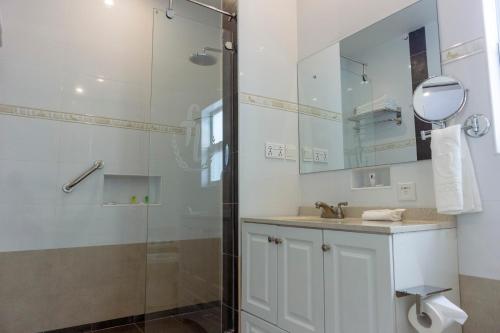 库马西Frederick's Lodge的带淋浴、盥洗盆和镜子的浴室