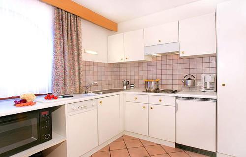 塞尔瓦迪加尔代纳山谷Residence Cesa Callegari的厨房配有白色橱柜和台面