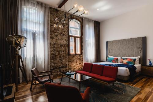 悉尼The Old Clare Hotel, Independent Collection by EVT的一间卧室配有一张床和一张红色的沙发